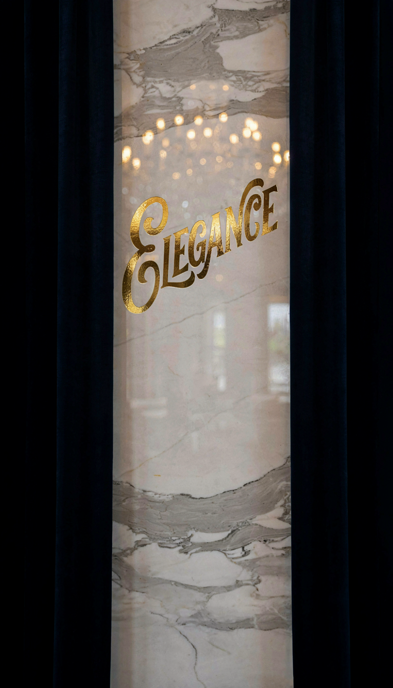 Generated result: gold foil embossed script lettering reading ELEGANCE on a marble pillar
